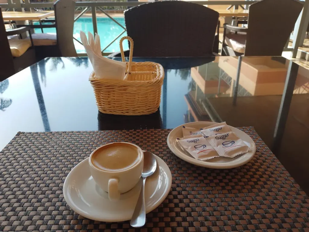 Single espresso overlooking the pool at Lowlands Hotel & Spa in Chuka during a Monday Field Notes customer service visit.